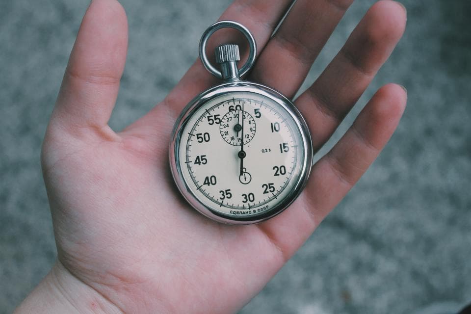 Hand houdt een stopwatch vast om tijd bij te houden