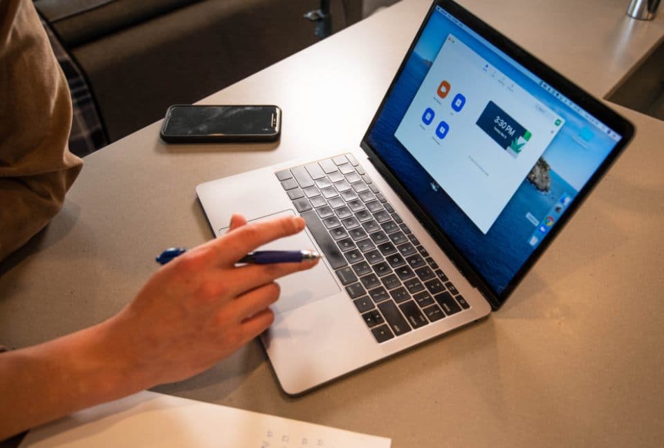 Medewerker werkt met pen en laptop aan een bureau