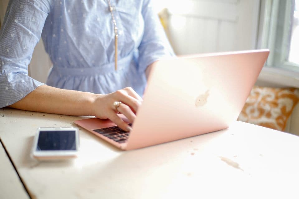 Medewerker typt op een laptop aan een licht bureau