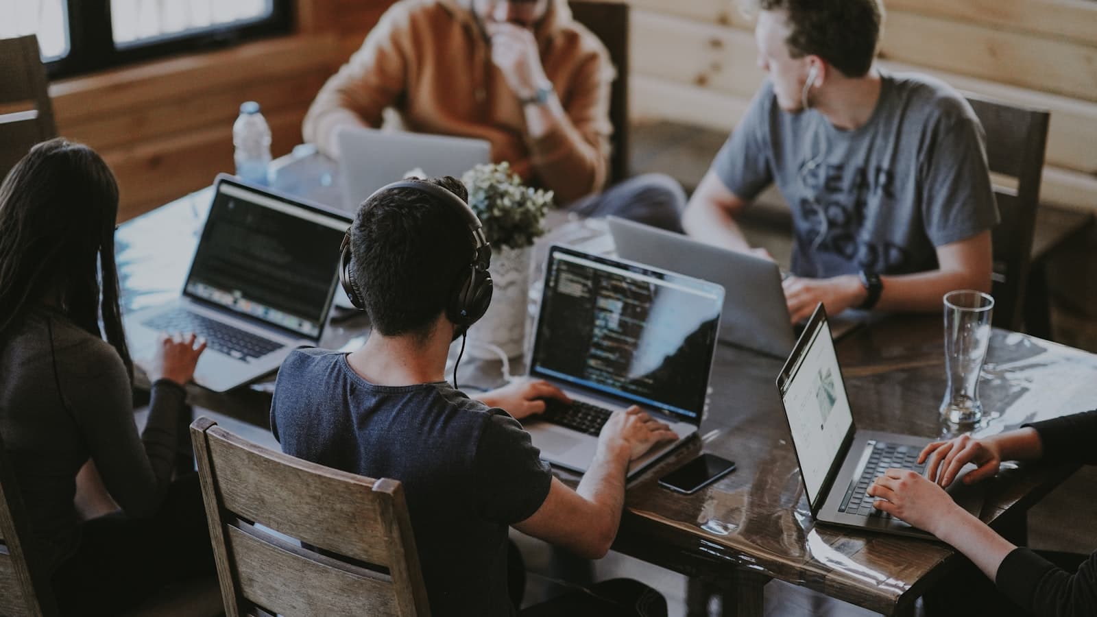 Klein team werkt geconcentreerd samen achter laptops in een moderne werkruimte