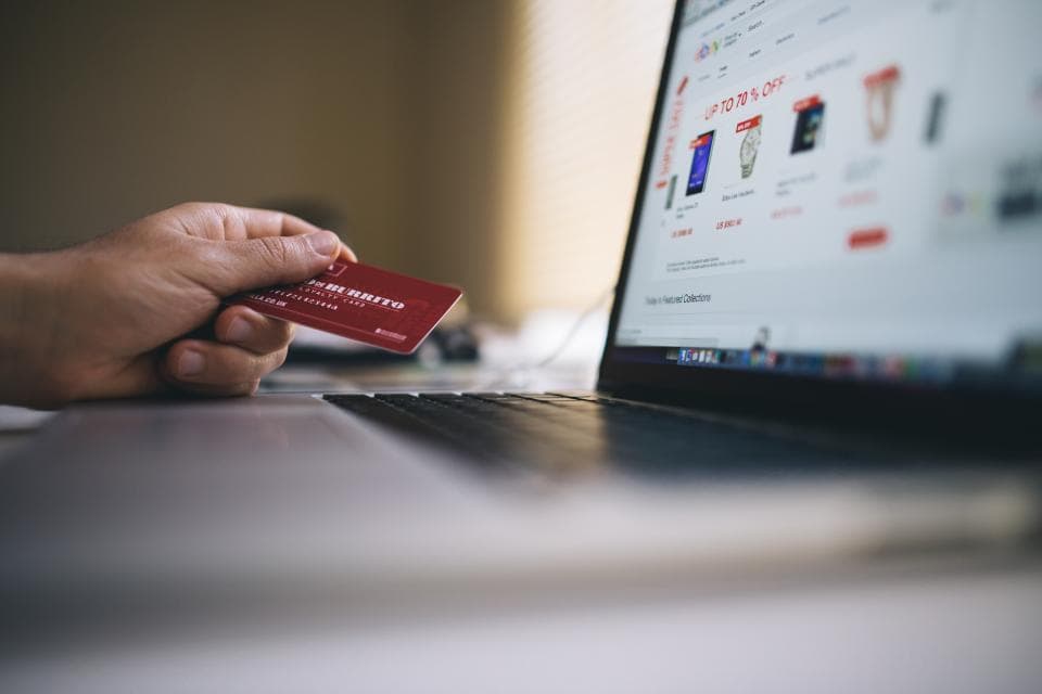 Klant rekent online af met een betaalpas voor een geopende laptop