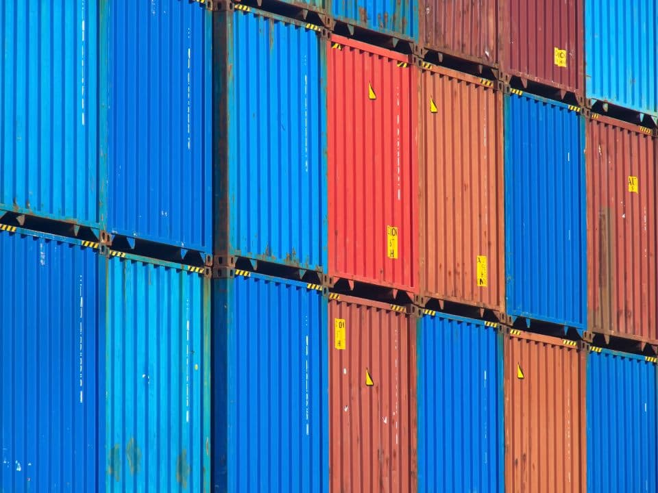 Gestapelde blauwe en rode zeecontainers op een containerterminal